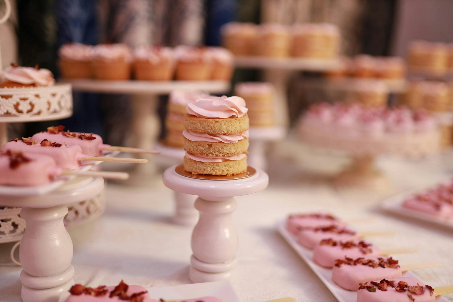 Vital Scheunep – Catering Grillwagen Geschirrverleih – ein wunderschöner Desserttisch im Rosa-Design, der wahrscheinlich für eine Feier wie eine Hochzeit oder eine Geburtstagsfeier gedeckt wird.